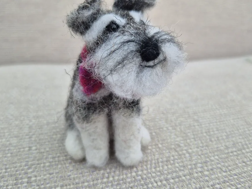 A needle-felted Schnauzer with a pink scarf